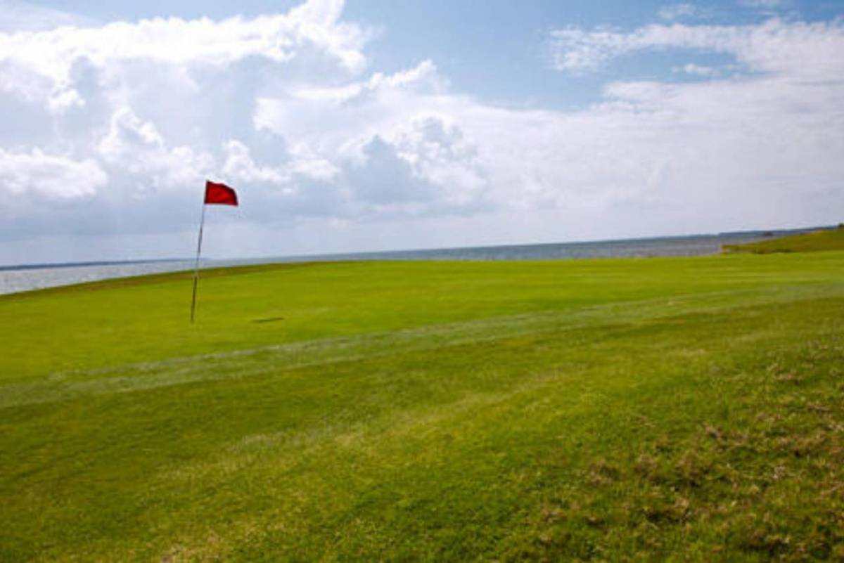 A red flag waves in the wind at the green on a hole at Nags Head Golf Links.